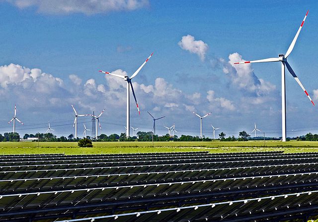 Solar panels, wind turbines, and an electricity pylon; unidentified location