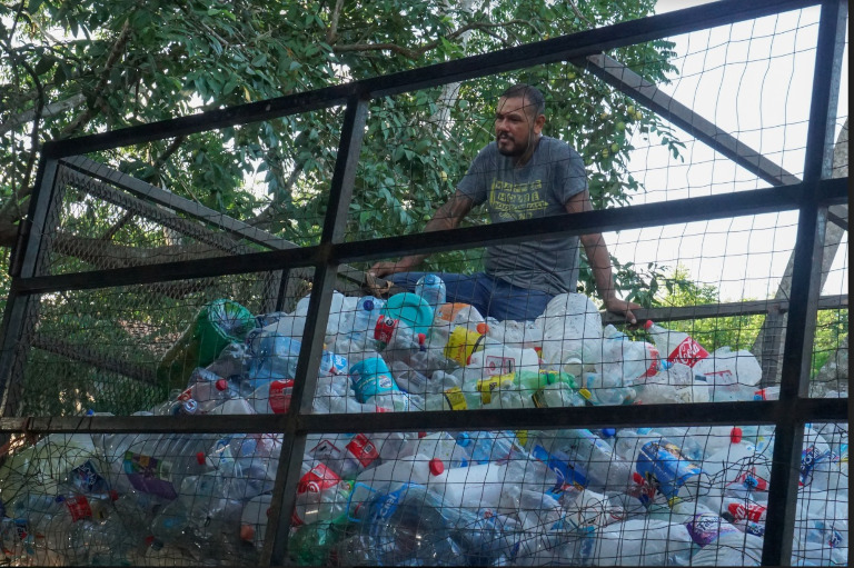 Eleno collects plastic trash for recycling.